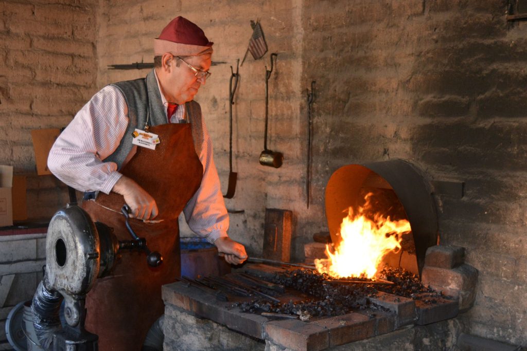 a man works on a blacksmith forge